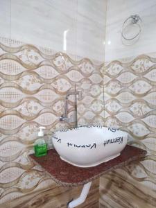 GhātsīlaKurchi Homestay的浴室设有水槽,墙上写着书写