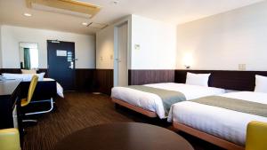 大津le Lac HOTEL Otsu Ishiyama的酒店客房设有两张床和一张桌子。