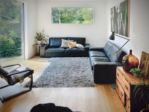 小谷村Cortina Apartment的客厅配有黑色沙发和地毯。