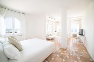 斯库索港Relais La Ghinghetta的一间白色的卧室,配有床和客厅