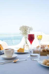 斯库索港Relais La Ghinghetta的一张桌子,上面放着两杯葡萄酒和食物