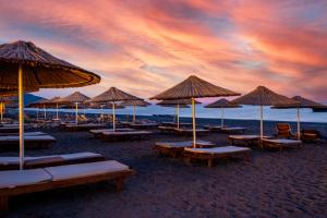 契拉勒卢卡别墅酒店的海滩上的一组沙滩椅和遮阳伞