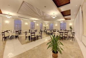 阿尔巴尤利亚阿乐格利亚酒店的宴会厅配有桌椅和窗户