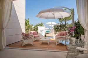 利尼亚诺萨比亚多罗Riviera Resort Hotel的庭院配有桌椅和遮阳伞。