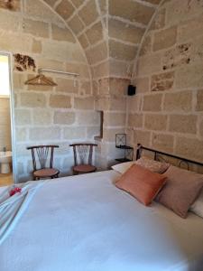 弗兰卡维拉丰塔纳Residenza Anima Mediterranea的卧室配有一张石墙内的大床