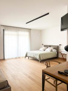 莱切Glass House - Smart Rooms & Parking的白色卧室配有床和桌子
