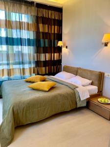 敖德萨Апартаменты Ясная Поляна的一间卧室配有一张带黄色枕头的床和一扇窗户