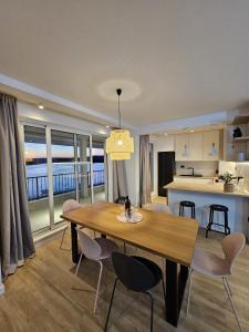 罗戈兹尼察Villa LUX Apartments的用餐室以及带桌椅的厨房。