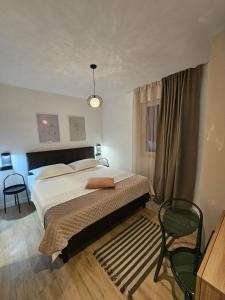 罗戈兹尼察Villa LUX Apartments的一间卧室配有一张大床和一把椅子