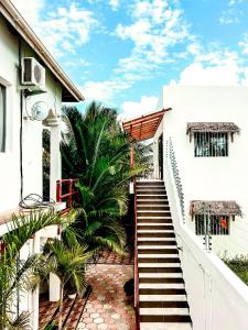 帕杰CeZeRe THE PALM HOTEL的通往白色棕榈树建筑的楼梯
