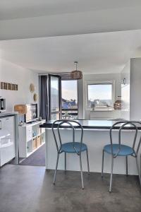 多维尔Cosy Deauville的一个带两把椅子的厨房和一个美景厨房岛