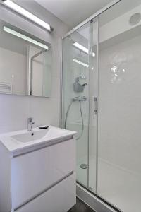多维尔Cosy Deauville的白色的浴室设有水槽和淋浴。