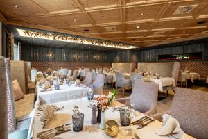 伊施格尔Alpenhotel Ischglerhof的餐厅内带桌椅的用餐室