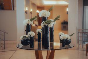 科威特萨佛酒店的一张桌子,上面有黑色花瓶,上面有白色的花