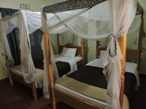 卡拉图Perigrin Rest House的卧室配有2张双层床和白色窗帘