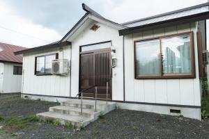 富良野Furano - House / Vacation STAY 56483的白色的房子,有门和窗户