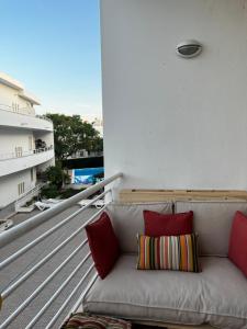 圣卢西亚岛Cozy Apartment的阳台的沙发上配有红色枕头