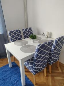 格丁尼亚Płyta 129的白色的桌子和椅子,蓝色的地毯