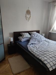 格丁尼亚Płyta 129的一间卧室配有一张带蓝色和白色棉被的床