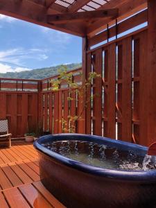 箱根马斯托米旅馆的木制甲板上的大型浴缸,设有庭院