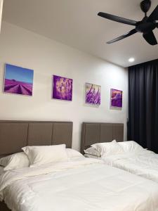古晋Cozzzy hut @ Riverine Diamond Kuching的卧室配有两张床,墙上挂有四张照片