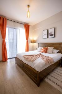 内罗毕LeR Homes的一间卧室配有带橙色窗帘的大床