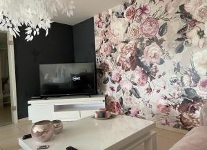 雅莱Résidence Birdie的客厅配有电视和花卉壁纸