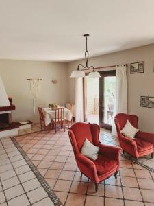 福尔米亚Mosè House的客厅配有2把红色椅子和桌子