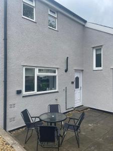 Cefn-coed-y-cymmerCosy 2 Bedroom House in Merthyr Tydfil Near Bike Park Wales & Brecon Beacons National Park的大楼前带桌椅的天井