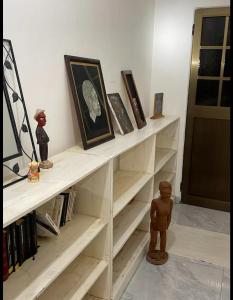 洛美Villa Stella的书架上装有书和娃娃的白色书架