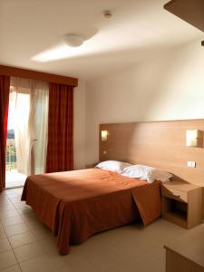 阿布鲁齐的罗塞托德玛尔公寓式酒店的一间卧室设有一张大床和一个窗户。