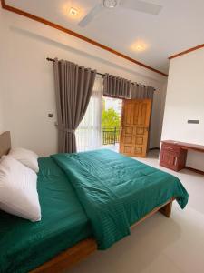尼拉瓦利The Reef Resort的一间卧室设有一张绿色的床和一个窗户。