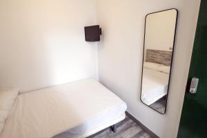 皮内达德马尔L'Hostalet GuestHouse的小房间设有床和镜子