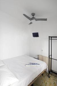 皮内达德马尔L'Hostalet GuestHouse的客房内的白色床和吊扇