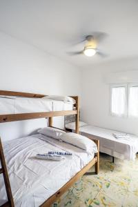 皮内达德马尔L'Hostalet GuestHouse的一间卧室设有两张双层床和吊扇