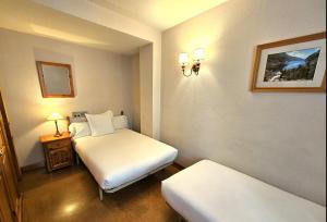 维耶拉安格拉达酒店的酒店客房设有两张床和床头柜。