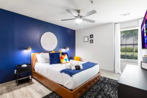 亚特兰大Modern Swank Luxury Aptmins The Battery3bd2br的一间卧室配有一张蓝色墙壁的床和吊扇