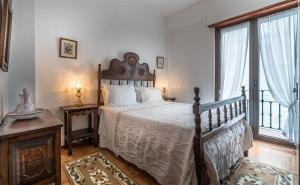 纳扎雷Solar dos Carvalhos - Apartamentos de Turismo的一间卧室设有一张床和一个大窗户
