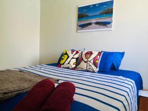 威廉斯塔德Bon Bini Kokolishi的一张带蓝色和白色条纹床单和枕头的床