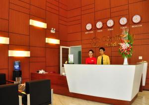 广义坎坦酒店的两名客人站在酒店大堂的柜台后面