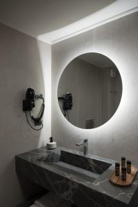 卡特罗斯南希 - 恰拉公寓式酒店的一间带大镜子的盥洗盆的浴室