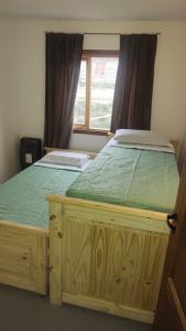 托尔胡因Hogar del Sur的一间卧室配有一张木床和窗户