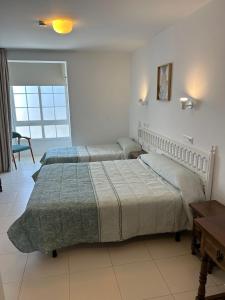 艾利亚德亚罗萨金雷伊酒店的一间卧室设有两张床、一张桌子和一个窗口