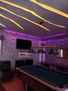 基希讷乌Villa5floors的紫色照明的房间里一张台球桌