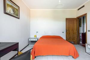 卡斯蒂里昂纳·德拉佩Casa Velio的一间卧室配有一张带橙色毯子的床