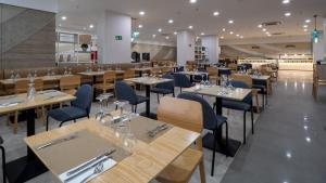 拉克鲁斯Hotel AF Valle Orotava的餐厅设有木桌和蓝色椅子