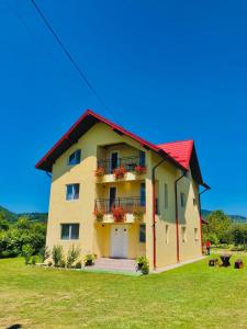 Oeşti-PămînteniVila Norina的黄色的房屋,有红色的屋顶