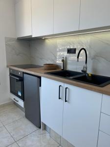 伊罗达Elounda Port Apartment的厨房配有白色橱柜和水槽
