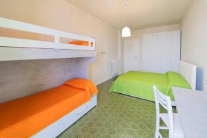 德瓦玛丽娜215 - Deiva al Mare, appartamento fronte mare con vista的一间卧室设有两张双层床和一张桌子