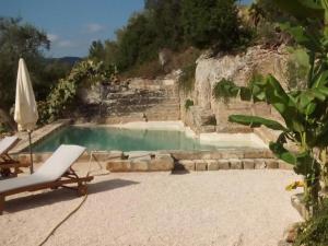 法萨诺Masseria Pelosella B&B的一个带椅子和遮阳伞的游泳池